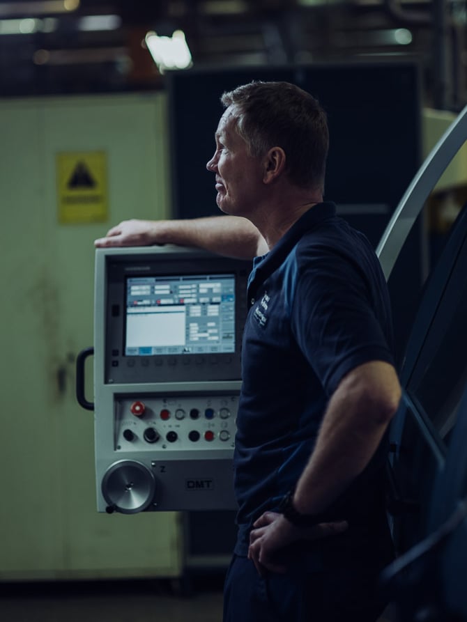 Man leaning on warehouse machinery in KALLER